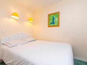 Appartement Avoriaz, 2 pièces, 5 personnes - FR-1-314-175 في مورزين: غرفة نوم بسرير ابيض ولوحة على الحائط