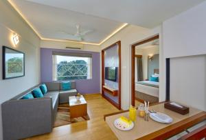 uma sala de estar com um sofá e uma mesa em Noah Sky Suites em Cochin
