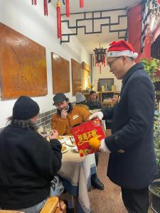 a group of people sitting at a table eating food at Wenjun Courtyard Hotel ---5 mins walk from Tonghuimen metro station, near Tianfu square, close by culture park and Sichuan opera house, English speaking service, local tours in Chengdu
