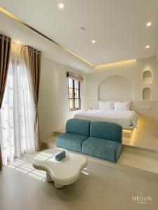 フーコックにあるMellon OASIS Phu Quocのベッドルーム(ベッド1台、青いソファ付)