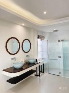 een badkamer met 2 wastafels en een douche bij Mellon OASIS Phu Quoc in Phu Quoc