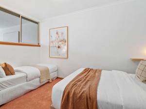 a white room with two beds and a couch at Yarrawonga Lakeside Apartment 38 in Mulwala