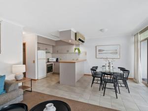 a kitchen and living room with a table and chairs at Yarrawonga Lakeside Apartment 38 in Mulwala