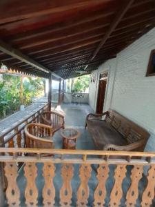 a porch with chairs and a couch on a balcony at Villa Embun Batukaras in Batukaras