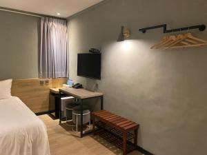 a bedroom with a bed and a desk and a tv at Prince Hotel in Jiaoxi