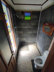 a small bathroom with a toilet and a window at Villa Embun Batukaras in Batukaras