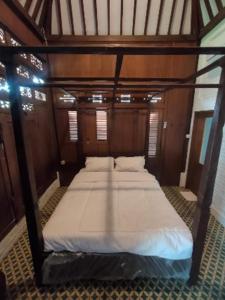 uma cama no meio de um quarto em Villa Embun Batukaras em Batukaras