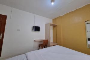 a bedroom with a bed and a tv on the wall at OYO 93493 Wira Residensia Syariah in Medan