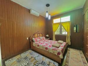 a bedroom with a bed and a rainbow painted wall at Tamteh Homestay in Ayer Hitam