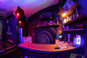 una camera con tavolo in una stanza con luci viola di Tripovali Guesthouse a Ko Phangan
