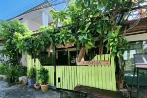 un edificio con una recinzione verde con alberi e piante di Tripovali Guesthouse a Ko Phangan