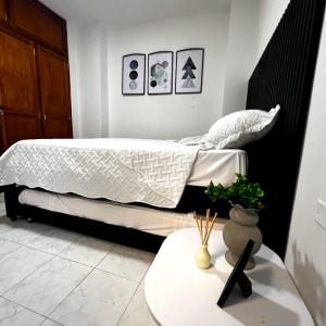 1 dormitorio con 1 cama y 1 mesa con sidra de mesa en Apartamentos San José, en Cartagena de Indias