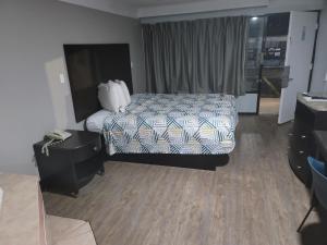 a hotel room with a bed and a dresser at Studio 6 Suites Hinesville, GA in Hinesville