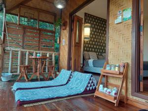 - une chambre avec un canapé et une table dans une maison dans l'établissement Ban Suan Nai Fun Homestay, à Pua