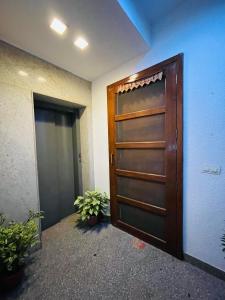 una puerta en una habitación con plantas delante de ella en Fortune Home Service Apartment 4Bhk,J-191 Saket, en Nueva Delhi