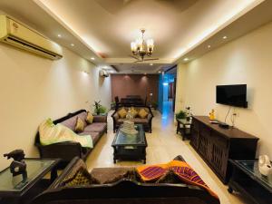 a living room with couches and a flat screen tv at Fortune Home Service Apartment 4Bhk,J-191 Saket in New Delhi