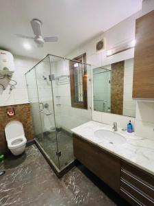 y baño con ducha, lavabo y aseo. en Fortune Home Service Apartment 4Bhk,J-191 Saket, en Nueva Delhi