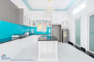 a kitchen with blue and white cabinets and a chandelier at Villages HOÀNG ĐỨC Full TIỆN ÍCH in Vung Tau