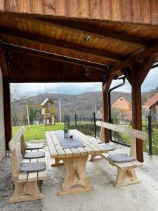 a picnic table and two chairs under a wooden pavilion at Holiday home Maklen with big garden and jacuzzi in Brod Moravice