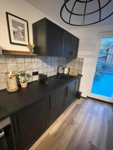 a kitchen with a black counter and a sink at Noir in Heidelberg