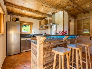 a kitchen with a large wooden counter with stools at Chalet La Clusaz, 5 pièces, 12 personnes - FR-1-437-9 in La Clusaz