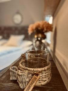 einem Holztisch mit einem Glas und einem Korb mit einer Vase in der Unterkunft "noir" in Heidelberg