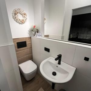 ein Badezimmer mit einem weißen Waschbecken und einem WC in der Unterkunft "noir" in Heidelberg