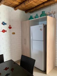 eine Küche mit einem weißen Kühlschrank und grünen Vasen an der Wand in der Unterkunft chalets cottage in Paracas