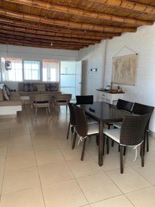 a dining room with a table and chairs and a couch at chalets cottage in Paracas