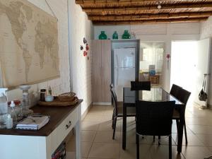 eine Küche mit einem Tisch und Stühlen sowie einem Kühlschrank in der Unterkunft chalets cottage in Paracas