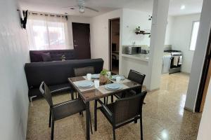 a dining table and chairs in a living room at Un rinconcito en Mérida in Mérida