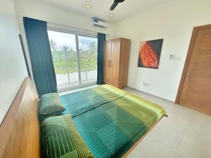 Cette chambre comprend un grand lit et une fenêtre. dans l'établissement Tropical Gem: 3-BR Beach Villa, à Pingwe