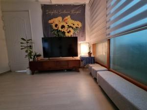 ein Wohnzimmer mit einem Flachbild-TV und einem Sofa in der Unterkunft Miz Soo House in Seoul