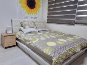 ein Bett in einem Schlafzimmer mit einem Sonnenblumenbild an der Wand in der Unterkunft Miz Soo House in Seoul