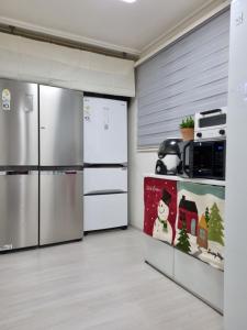 eine Küche mit einem Kühlschrank aus Edelstahl in einem Zimmer in der Unterkunft Miz Soo House in Seoul