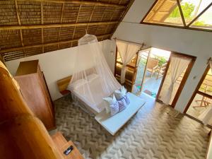 um quarto com uma cama com uma rede em Surya Beach Resort Palawan em Aborlan
