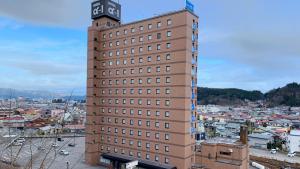 高山市にあるホテルアルファーワン高山バイパスの頂上に時計塔がある高い建物