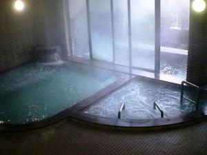 Una gran piscina de agua en una habitación con ventana en Hotel Alpha-One Takayama Bypass, en Takayama