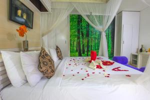 a bedroom with a white bed with confetti on it at One Bedroom Private Villa Kuta in Seminyak
