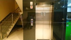 un ascensor en un edificio con un teléfono en la pared en Goroomgo Hotel Home Town Near Golden Beach Puri, en Puri
