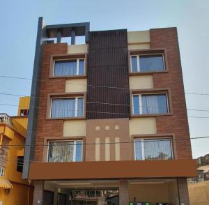 a tall brick building with windows at Goroomgo Hotel Home Town Near Golden Beach Puri in Puri
