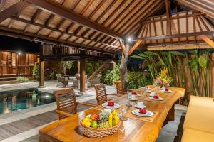 an outdoor dining area with a table with fruit on it at Villa Lina by Optimum Bali Villas in Canggu