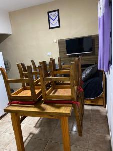comedor con sillas de madera y TV en Departamento Genaro en Mina Clavero