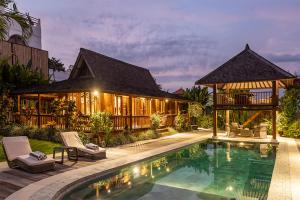 a villa with a swimming pool and a house at Villa Lina by Optimum Bali Villas in Canggu