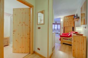 a living room with wooden doors and a red chair at Studio Grange Nest Ski & Relax - Happy Rentals in Sestriere