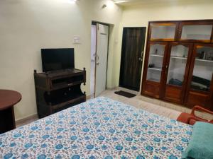 a bedroom with a bed and a dresser and a television at INDEPENDENT PEACE FULL GUAST HOUSE in Tanuku