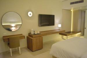 een slaapkamer met een bed en een bureau met een spiegel bij Reef Oasis Beach Aqua Park Resort in Sharm El Sheikh