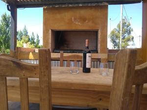una botella de vino en una mesa de madera con copas en Pensamientos del alma (Uribelarrea) en Uribelarrea