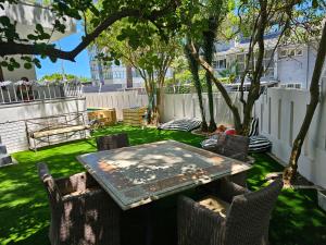 a table and chairs in a yard with a tree at WunderLux in Cape Town