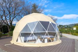 渋川市にあるglampark Healthy Pal Gunmaの木製デッキに座る大型ドームテント